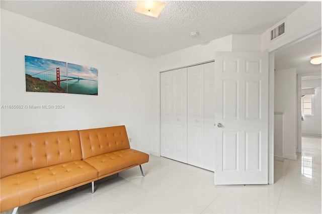 sitting room featuring a textured ceiling and light tile patterned flooring