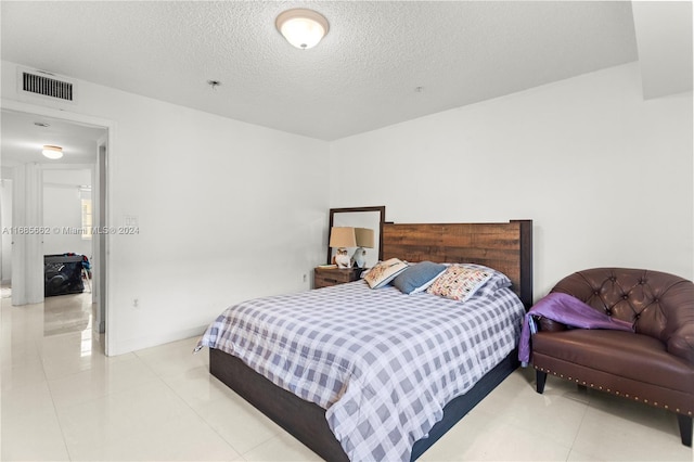 bedroom featuring a textured ceiling and light tile patterned flooring