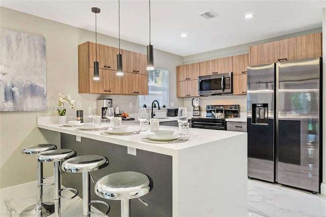 kitchen featuring a breakfast bar area, stainless steel appliances, hanging light fixtures, kitchen peninsula, and sink