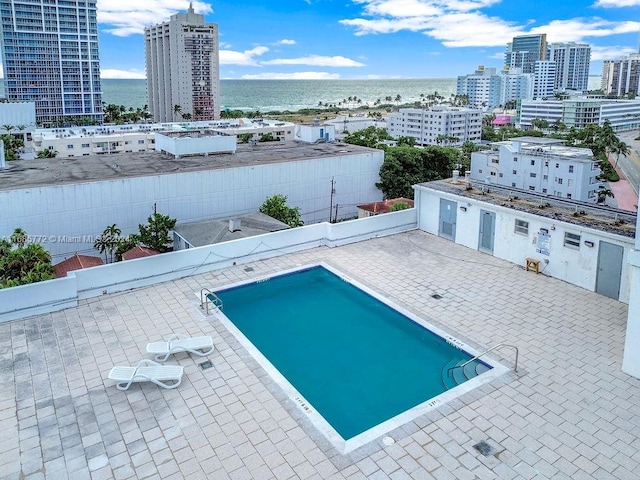 view of pool featuring a patio and a water view