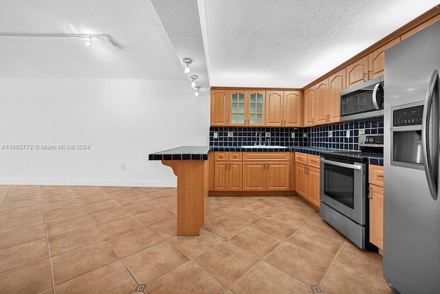 kitchen with kitchen peninsula, stainless steel appliances, backsplash, a breakfast bar, and light tile patterned floors