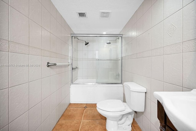 full bathroom with vanity, toilet, tile walls, and combined bath / shower with glass door