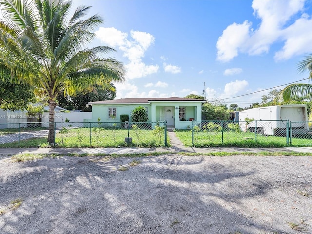 710 E 39th St, Hialeah, FL 33013 - view of front of house with stucco siding, a fenced front yard, and a gate