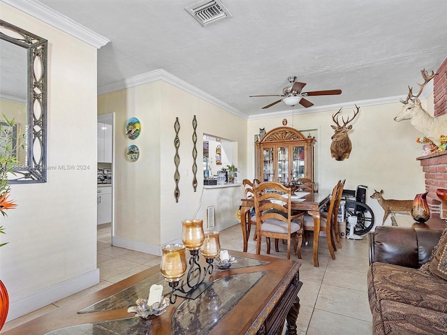 dining area with ceiling fan, light tile patterned floors, a textured ceiling, ornamental molding, and a fireplace