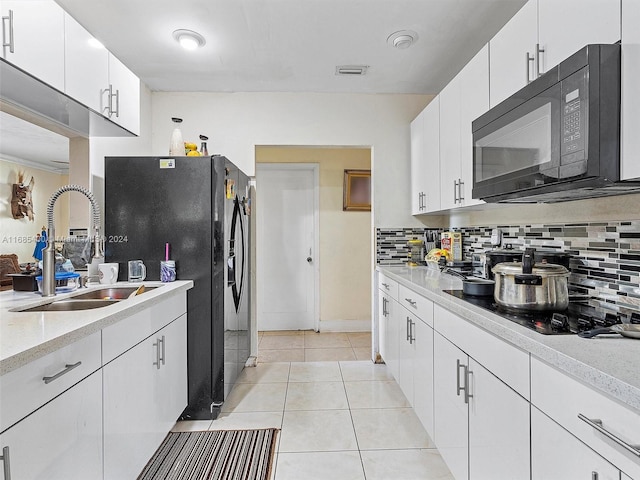 kitchen with white cabinetry, black appliances, sink, and backsplash