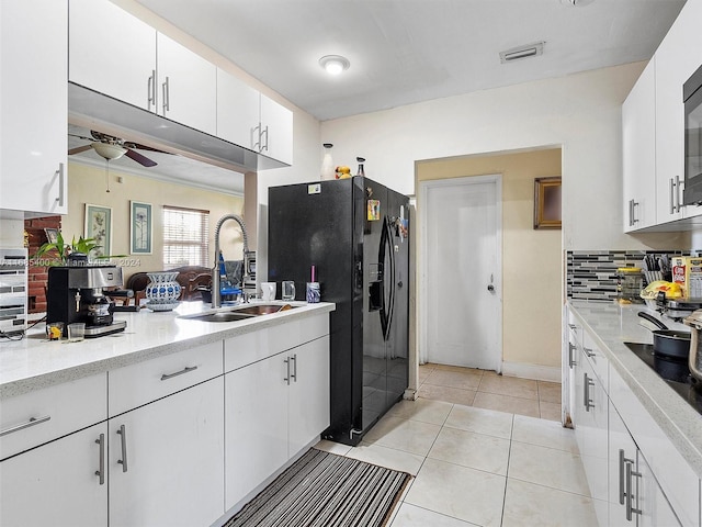 710 E 39th St, Hialeah, FL 33013 - kitchen with a sink, black fridge with ice dispenser, decorative backsplash, a ceiling fan, and white cabinetry