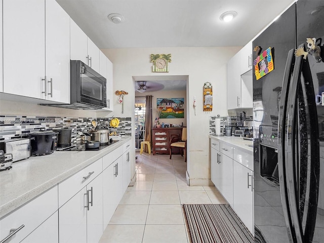 kitchen featuring decorative backsplash, white cabinets, and black appliances