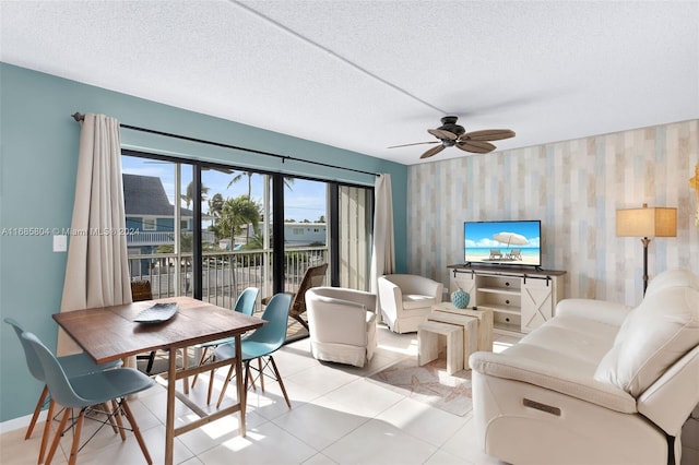 living room featuring a textured ceiling, ceiling fan, and light tile patterned floors