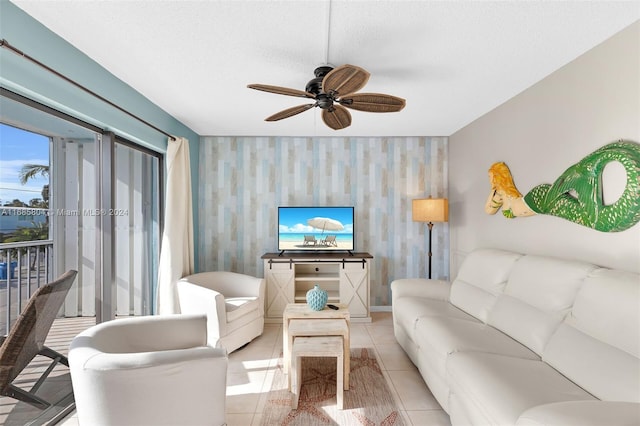 living room featuring ceiling fan, a textured ceiling, and light tile patterned flooring