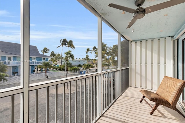 unfurnished sunroom featuring ceiling fan