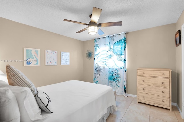 tiled bedroom featuring ceiling fan and a textured ceiling