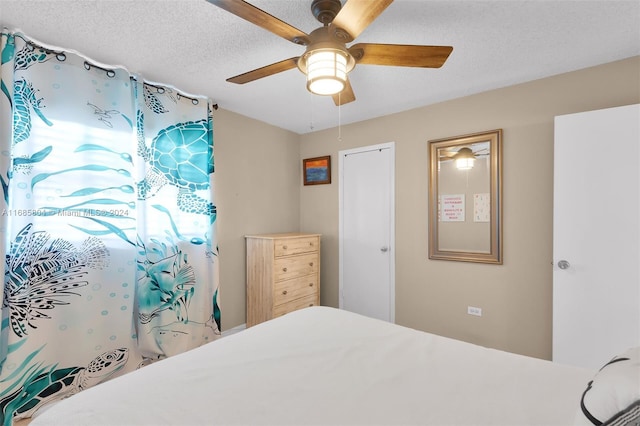 bedroom with a textured ceiling and ceiling fan