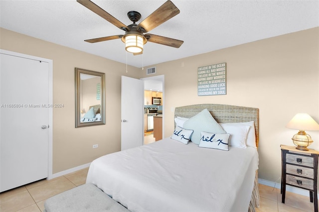 tiled bedroom with a textured ceiling and ceiling fan