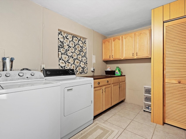 laundry room featuring light tile patterned floors, cabinets, and washing machine and clothes dryer