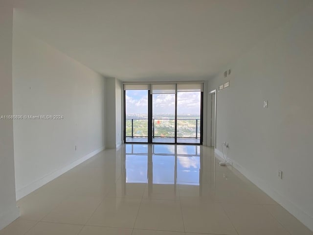 tiled spare room featuring floor to ceiling windows