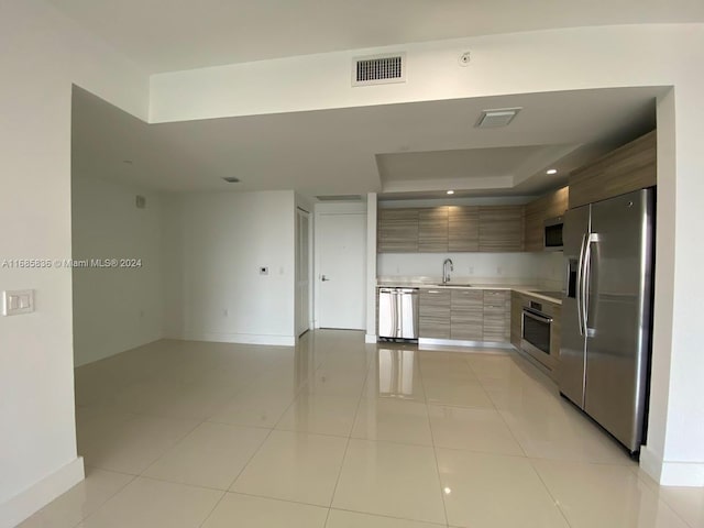 kitchen featuring stainless steel appliances, sink, and light tile patterned floors