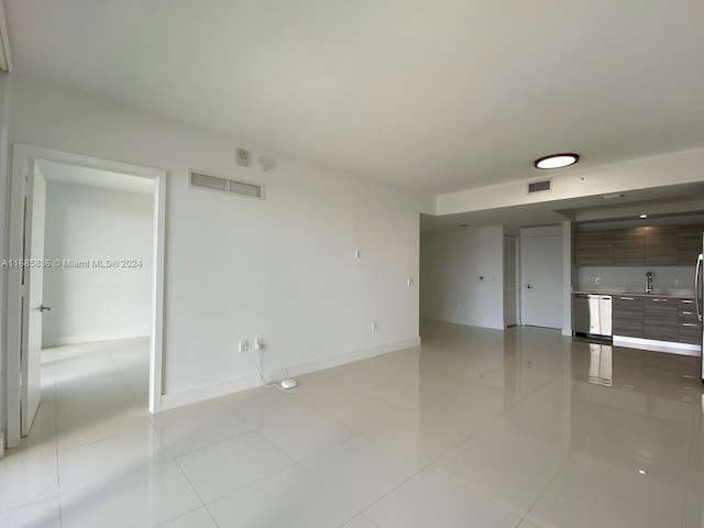 empty room featuring sink and light tile patterned flooring