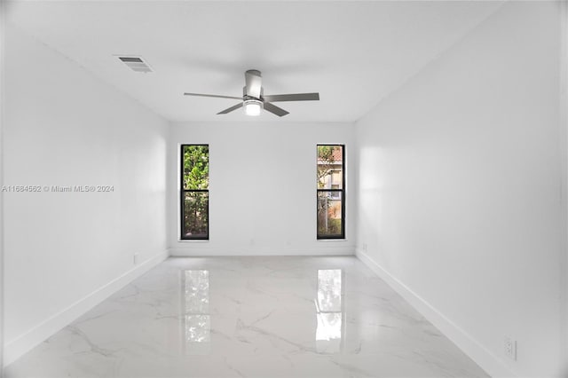 spare room featuring ceiling fan and plenty of natural light