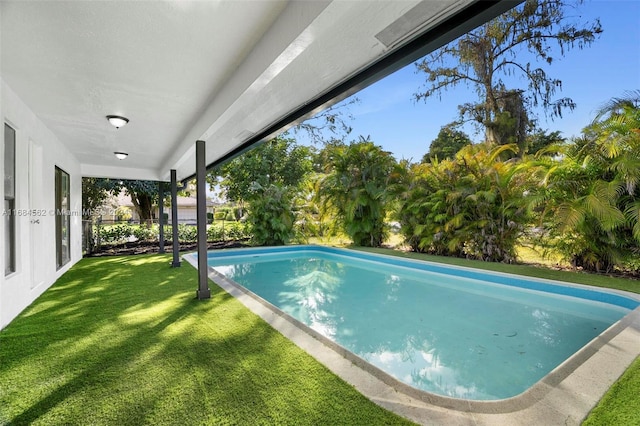 view of swimming pool featuring a yard