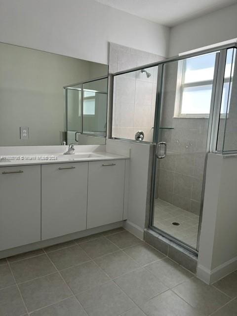 bathroom with vanity, tile patterned floors, and a shower with door