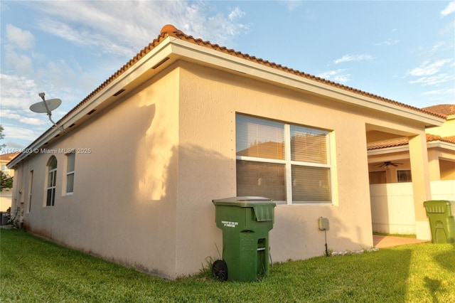 view of side of property with a lawn and stucco siding