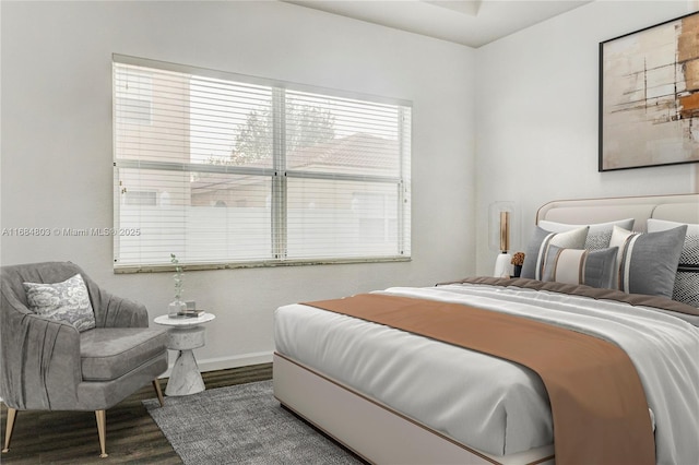 bedroom with baseboards and wood finished floors