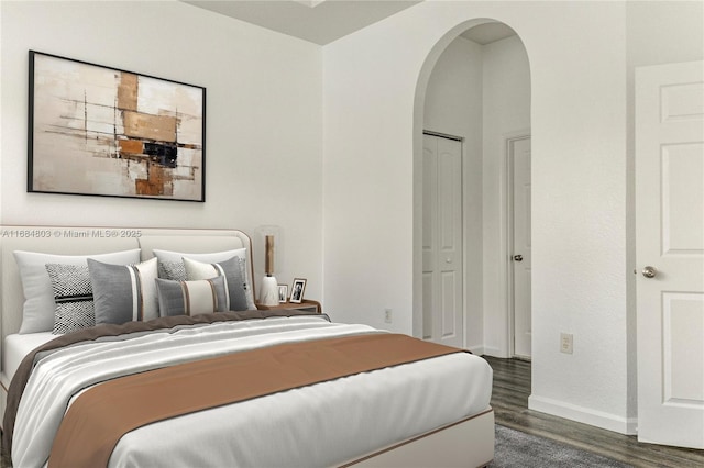 bedroom featuring dark wood-type flooring, arched walkways, and baseboards