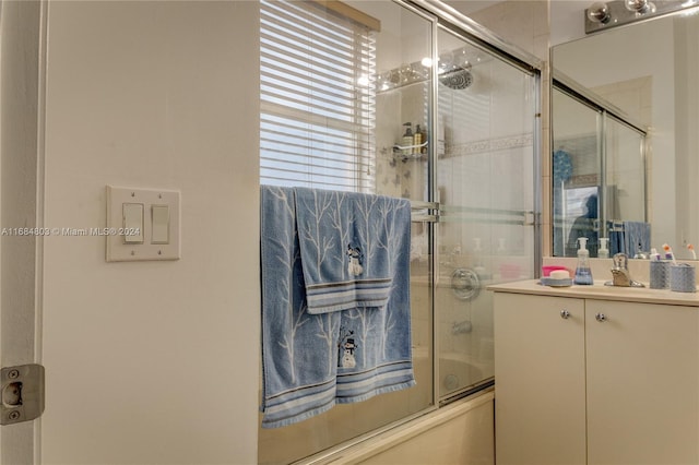 bathroom with vanity and bath / shower combo with glass door