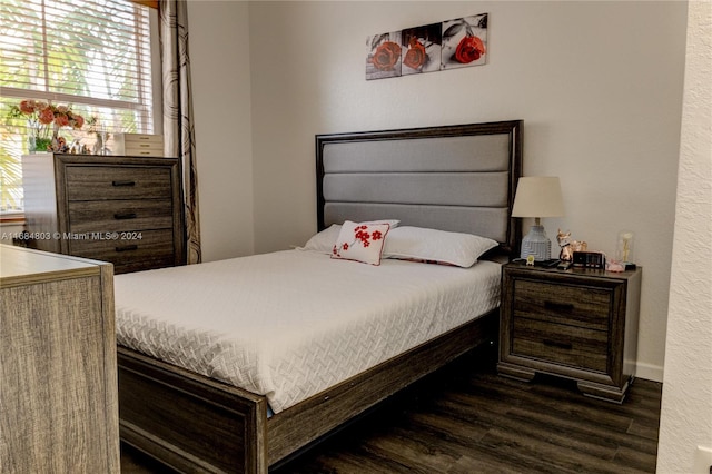 bedroom with dark hardwood / wood-style flooring