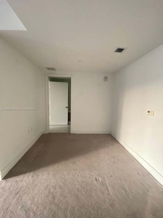 spare room featuring light colored carpet