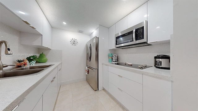 kitchen featuring white cabinetry, appliances with stainless steel finishes, sink, and light tile patterned floors