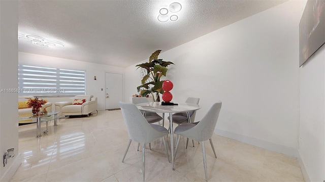 unfurnished dining area with a textured ceiling and light tile patterned floors