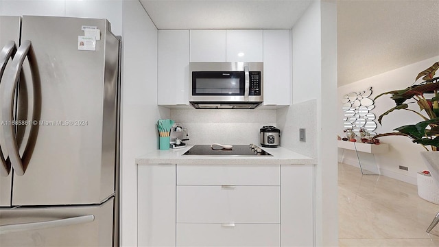 kitchen with stainless steel appliances, white cabinets, and light tile patterned floors