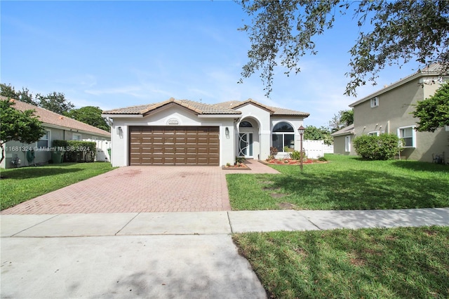 mediterranean / spanish-style home with a garage and a front yard