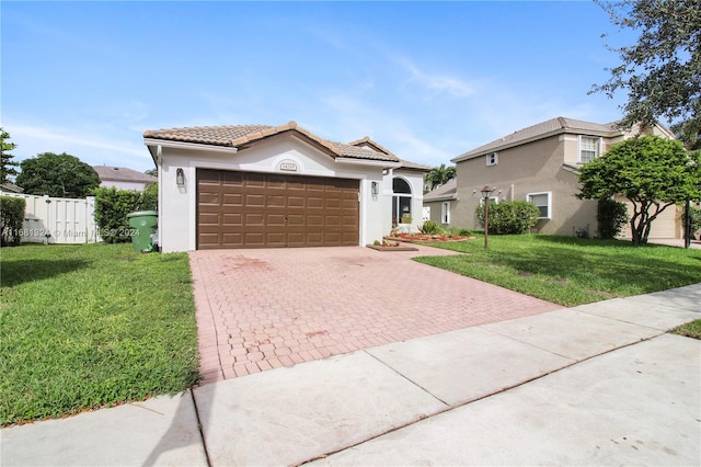 mediterranean / spanish house with a garage and a front lawn