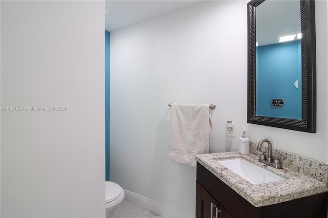 bathroom with tile patterned flooring, vanity, and toilet