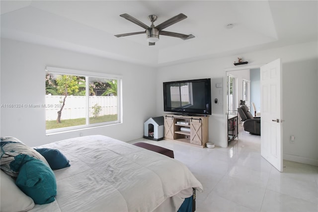 bedroom with ceiling fan and a raised ceiling