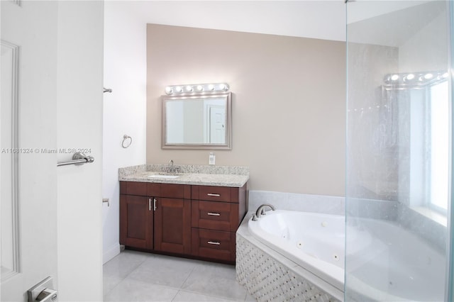 bathroom featuring vanity, a relaxing tiled tub, and tile patterned flooring