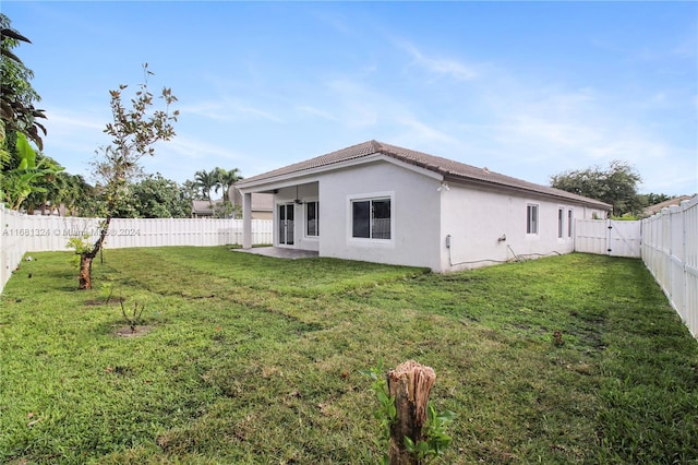 back of property with a patio and a lawn