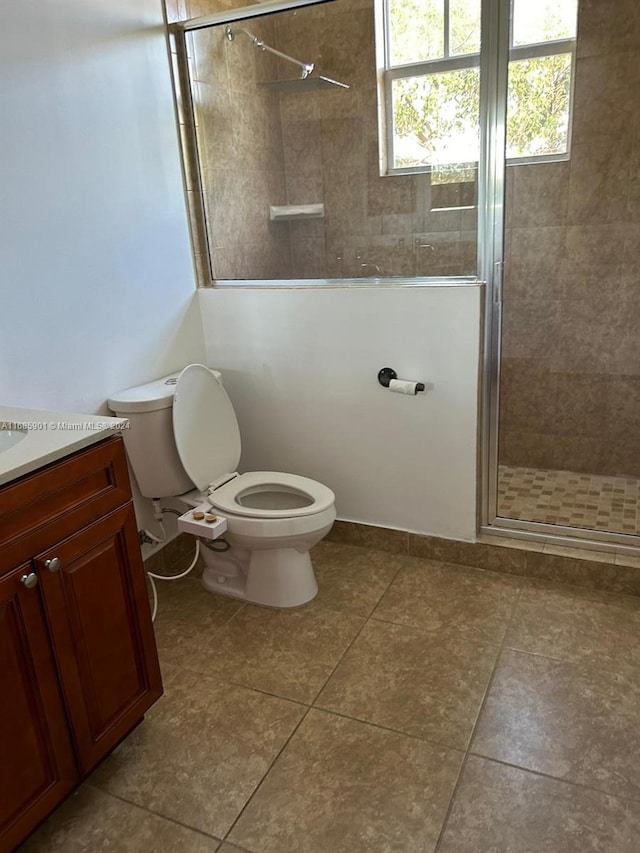 bathroom featuring vanity, toilet, tile patterned floors, and an enclosed shower