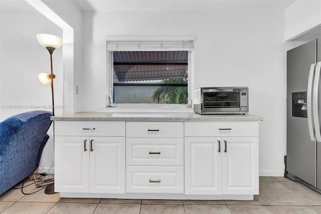 kitchen featuring white cabinetry, light tile patterned floors, stainless steel fridge with ice dispenser, and pendant lighting