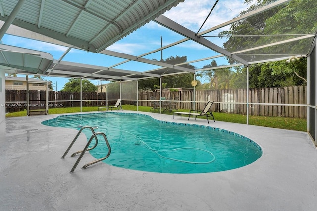 view of swimming pool featuring a patio, glass enclosure, and a lawn