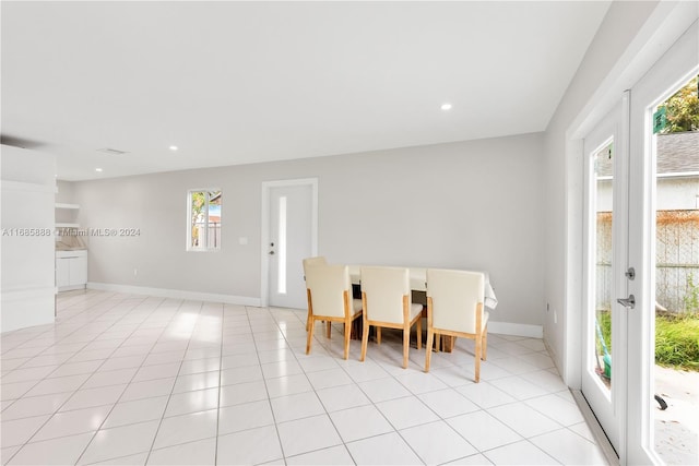 tiled dining space featuring french doors and a healthy amount of sunlight