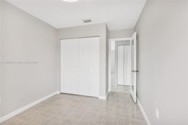 unfurnished bedroom featuring a closet and light tile patterned floors