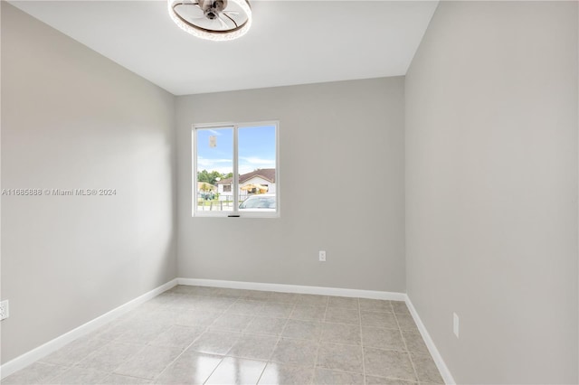 tiled empty room featuring ceiling fan