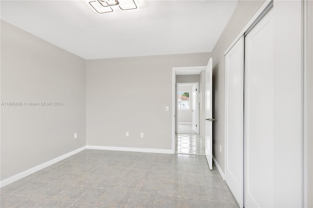 unfurnished bedroom with light tile patterned flooring and a closet