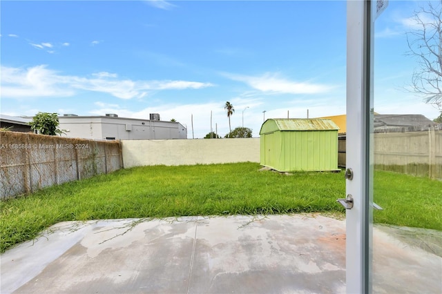 view of yard with a shed and a patio area