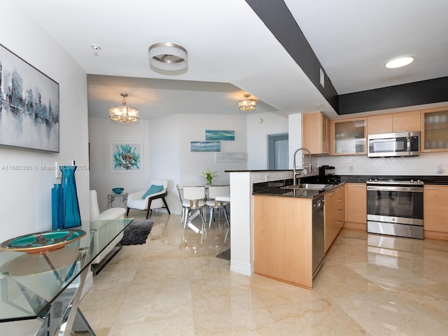 kitchen featuring sink, hanging light fixtures, decorative backsplash, appliances with stainless steel finishes, and kitchen peninsula