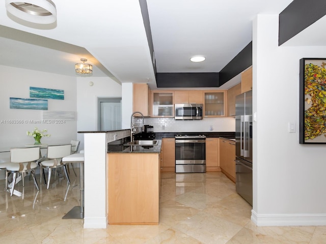 kitchen featuring kitchen peninsula, decorative backsplash, sink, and stainless steel appliances