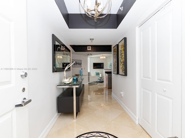 hallway with a notable chandelier and light tile patterned floors